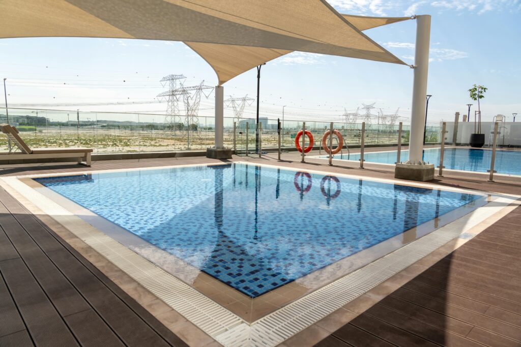 Outdoor swimming pool with sun shade in Dubai, showcasing a pleasant outdoor atmosphere.
